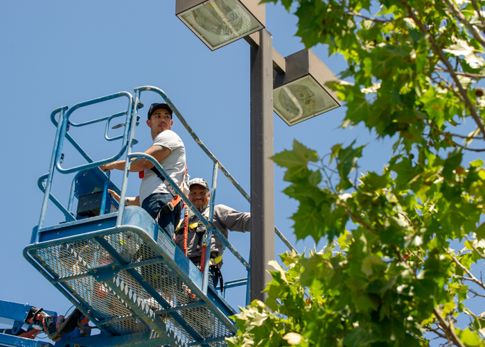 Apprentices servicing commercial lighting from a boom lift