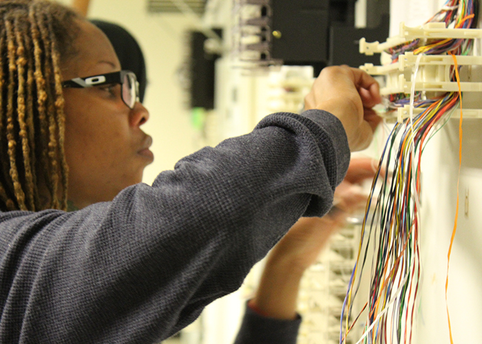 A WECA apprentice terminating low voltage wiring at a panel