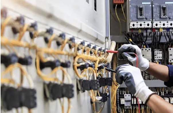 An apprentice wiring a device by hand